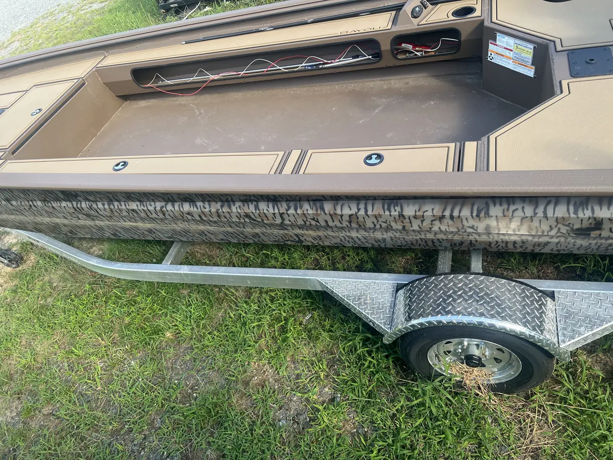 Camo-wrapped boat and trailer getting wired up