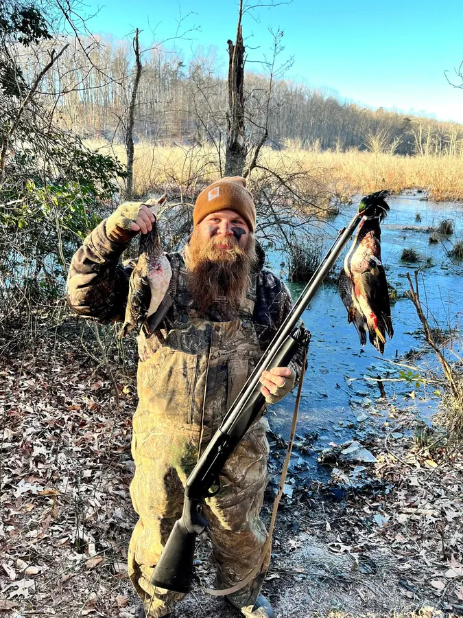 Matt Crenshaw holding ducks after a hunt